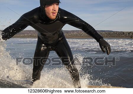 Stock Photograph - Man surfing, South-central Alaska; Homer, Alaska, United States of America. Fotosearch
