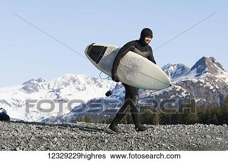 Man walking with a surfboard, Kenai Peninsula Outer Coast, South-central Alaska; Alaska, United States of America View Large Photo Image Stock Photograph - Man walking with a surfboard, Kenai Peninsula Outer Coast, South-central Alaska; Alaska, United States of America. Fotosearch