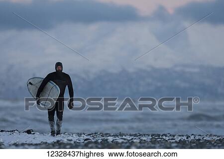 Man with surfboard walking on the snow on Homer beach in winter, South-central Alaska; Homer, Alaska, United States of America View Large Photo Image Stock Photograph - Man with surfboard walking on the snow on Homer beach in winter, South-central Alaska; Homer, Alaska, United States of America. Fotosearch