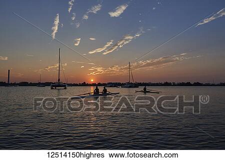 Stock Photograph - Members of the Hanlan Boat Club practicing in the early morning; Toronto, Ontario, Canada. Fotosearch