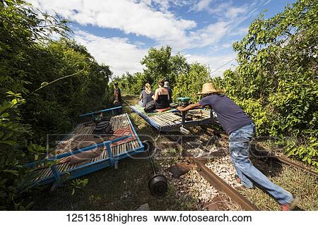 Men pushing the bamboo platform of the Norry, the bamboo train; Battambang, Cambodia View Large Photo Image Stock Photograph - Men pushing the bamboo platform of the Norry, the bamboo train; Battambang, Cambodia. Fotosearch