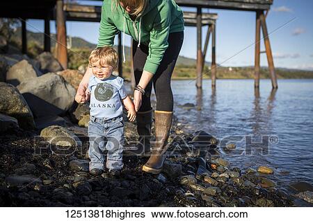Stock Photograph - Mother and son along the Homer shoreline, Kenai Peninsula, South-central Alaska; Homer, Alaska, United States of America. Fotosearch