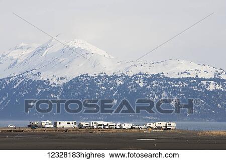 Stock Photograph - Motorhomes Parked On The Homer Spit With The Kenai Mountains In The Background, Kachemak Bay State Park, Southcentral Alaska, USA. Fotosearch