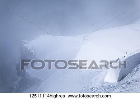 Mountain climbers are heading to Mont Blanc in fog, viewed from Aiguille du midi; Chamonix-Mont-Blanc, Haute-Savoie, France View Large Photo Image Stock Photograph - Mountain climbers are heading to Mont Blanc in fog, viewed from Aiguille du midi; Chamonix-Mont-Blanc, Haute-Savoie, France. Fotosearch