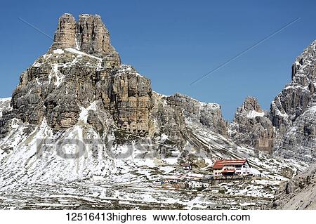 Mountain hotel on a snow-covered rocky ridge with mountains and blue sky in the background; Sesto, Bolzano, Italy View Large Photo Image Stock Photograph - Mountain hotel on a snow-covered rocky ridge with mountains and blue sky in the background; Sesto, Bolzano, Italy. Fotosearch
