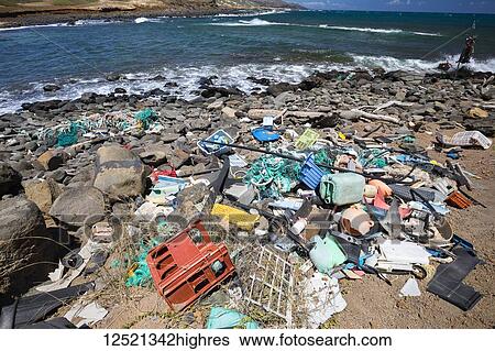 Stock Photograph - Much of the north side of the island of Molokai in inaccessible. Trade winds blow onshore regularly bringing with them piles of plastic that has been floating around the Pacific Ocean for years and years; Molokai, Hawaii, United States of America. Fotosearch