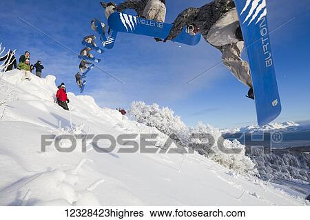 Stock Photograph - Multiple exposure of snowboarder making a jump on a hillside, Homer, Southcentral Alaska, USA. Fotosearch