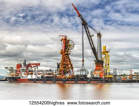 Stock Photograph - Offshore vessel in dock with crane; North Shields, Tyne and Wear, England. Fotosearch