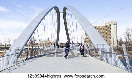 Pedestrians and cyclists going across a bridge over the Bow River; Calgary, Alberta, Canada View Large Photo Image Stock Photograph - Pedestrians and cyclists going across a bridge over the Bow River; Calgary, Alberta, Canada. Fotosearch