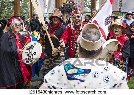Stock Photograph - People at the Tlingit Celebration, participants are entering the hall to traditional drumming; Teslin, Yukon, Canada. Fotosearch