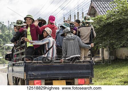 Stock Photograph - People riding in the back of a truck; Phonsavan, Xiangkhouang, Laos. Fotosearch
