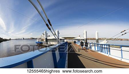 Stock Photograph - People walking down the pier towards a ferry on the River Tyne; South Shields, Tyne and Wear, England. Fotosearch