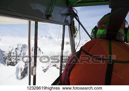 Stock Photograph - Pilot flying a Piper Super Cub around the Kenai Mountains, Kachemak Bay State Park, South-central Alaska; Alaska, United States of America. Fotosearch