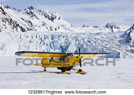 Stock Photograph - Piper Super Cub plane, Kenai Mountains, Kachemak Bay State Park, Grewingk Glacier, Southcentral Alaska; Alaska, United States of America. Fotosearch