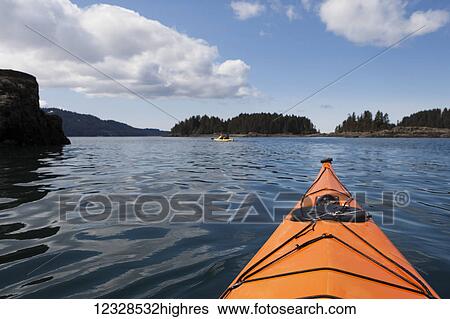 Stock Photograph - Point of view while sea kayaking in Kachemak Bay in the spring, South-central Alaska; Alaska, United States of America. Fotosearch