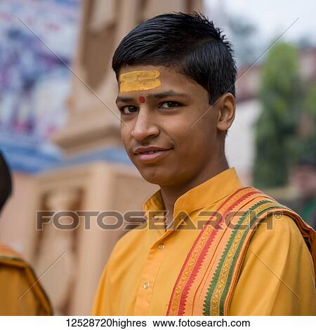 Stock Photograph - Portrait of a boy, Ganga Aarti in Rishikesh, a Hindu devotional ritual on the Ganges; Rishikesh, Uttarakhand, India. Fotosearch