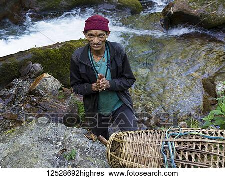 Portrait of a Hindu man standing near a stream and looking up; Bhalu Khop Village, Sikkim, India View Large Photo Image Stock Photograph - Portrait of a Hindu man standing near a stream and looking up; Bhalu Khop Village, Sikkim, India. Fotosearch