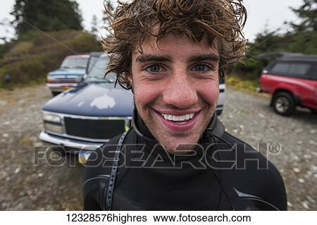 Stock Photograph - Portrait of a surfer near Yakutat, Southeast Alaska; Alaska, United States of America. Fotosearch