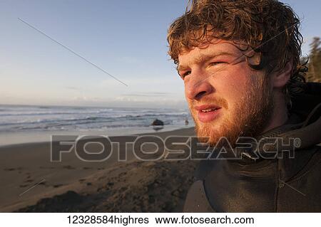 Stock Photograph - Portrait of a surfer near Yakutat, Southeast Alaska; Alaska, United States of America. Fotosearch