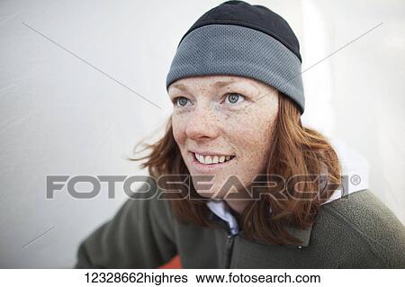 Stock Photograph - Portrait of a woman with red hair and freckles in the early morning in a tent while camping near Swanson Lake, Kenai Peninsula, South-central Alaska; Alaska, United States of America. Fotosearch