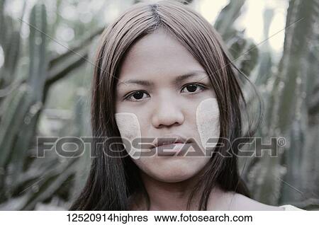 Stock Photograph - Portrait of a young woman from Myanmar with white face paint on her cheeks; Bagan, Myanmar. Fotosearch