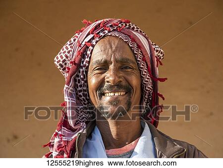 Stock Photograph - Portrait of an Eritrean man smiling with a headscarf on his head, Monday livestock market; Keren, Anseba Region, Eritrea. Fotosearch