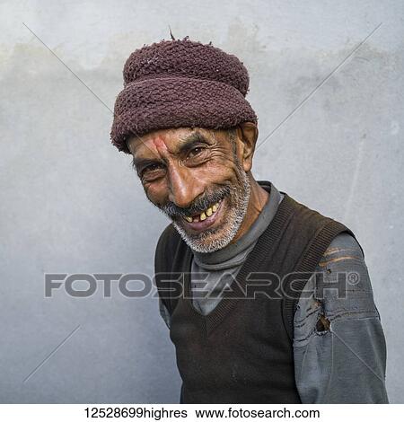 Stock Photograph - Portrait of an Indian man with a toothy grin and wearing a hat; Radhu Khandu Village, Sikkim, India. Fotosearch