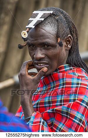 Stock Photograph - Portrait of Maasai warrior with braided hairstyle and wearing traditional clothing in the Ngorongoro Conservation Area; Tanzania. Fotosearch