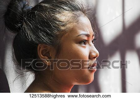 Stock Photograph - Portrait of the profile of a Cambodian girl at the School of Art; Siem Reap, Cambodia. Fotosearch