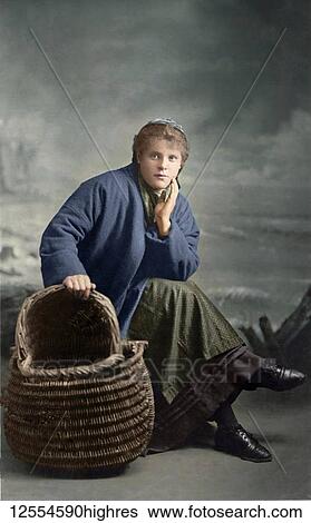 Stock Photograph - Postcard circa 1900, Victorian/Edwardian Social History. A portrait of a fisherlass from Cullercoats with her basket; Cullercoats, England. Fotosearch