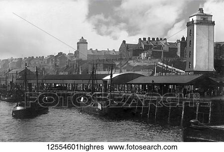 Postcard circa 1900, Victorian/Edwardian Social History. A view of North Shields Fish Quay showing steam driven fishing boats, houses and the low and high lights (lighthouses), people walking and working on the fish quay; North Shields, Tyne and Wear,... View Large Photo Image Stock Photograph - Postcard circa 1900, Victorian/Edwardian Social History. A view of North Shields Fish Quay showing steam driven fishing boats, houses and the low and high lights (lighthouses), people walking and working on the fish quay; North Shields, Tyne and Wear,.... Fotosearch