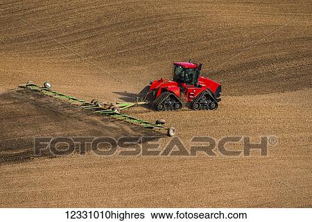 Stock Photograph - Quadtrac Tractor Harrowing A Garbanzo Bean Seedbed In The Palouse Region Of Eastern Washington; Washington, United States Of America. Fotosearch