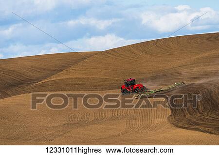 Stock Photograph - Quadtrac Tractor Harrowing A Garbanzo Bean Seedbed In The Palouse Region Of Eastern Washington; Washington, United States Of America. Fotosearch