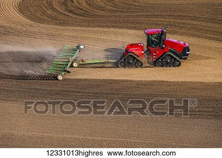 Stock Photograph - Quadtrac Tractor Harrowing A Garbanzo Bean Seedbed In The Palouse Region Of Eastern Washington; Washington, United States Of America. Fotosearch