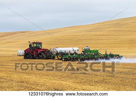 Stock Photograph - Quadtrac Tractor Pulling An Anhydrous Ammonia Tank And Applicator Applying The Anhydrous To A Field In Advance Of Preparing It For Planting In The Palouse Region Of Eastern Washington; Washington, United States Of America. Fotosearch