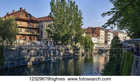 Stock Photograph - Reflections In A Tranquil Canal Of Residential Buildings And Trees; Ljubljana, Slovenia. Fotosearch