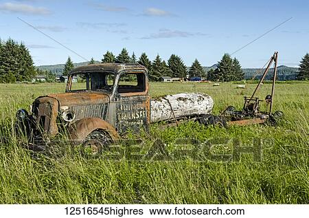 Stock Photograph - Rusted and dilapidated flatbed truck sitting in a field, Southeast Alaska; Gustavus, Alaska, United States of America. Fotosearch
