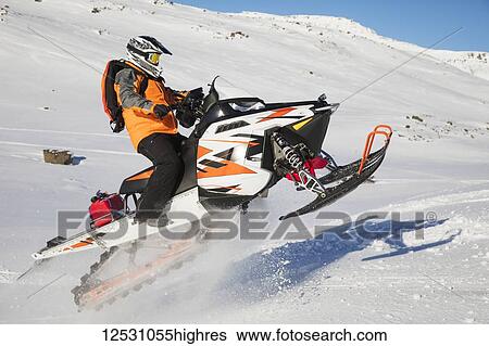 Stock Photograph - S0wmobiler having fun in the mountains surrounding Djupavik; West Fjords, Iceland. Fotosearch