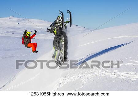 Stock Photograph - S0wmobiler having fun in the mountains surrounding Djupavik; West Fjords, Iceland. Fotosearch