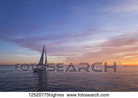 Stock Photograph - Sailboat at sunset; Santa Barbara, California, United States of America. Fotosearch