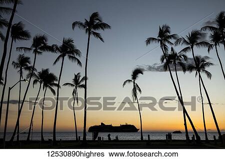 Stock Photograph - Silhouette of a cruise ship on the water off the shore of Kailua Bay at sunset; Kailua-Kona, Island of Hawaii, Hawaii, United States of America. Fotosearch