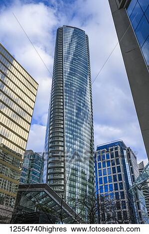 Skyscraper with glass facade reflecting blue sky and clouds; Vancouver, British Columbia, Canada View Large Photo Image Stock Photograph - Skyscraper with glass facade reflecting blue sky and clouds; Vancouver, British Columbia, Canada. Fotosearch