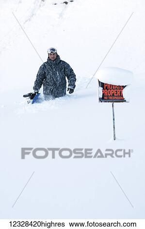 Stock Photograph - Snowboarder in deep snow on private property, Homer, Southcentral Alaska, USA. Fotosearch