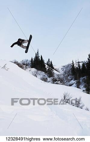 Stock Photograph - Snowboarder in mid-jump, South-central Alaska, Homer, Alaska, United States of America. Fotosearch