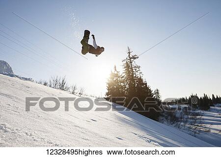 Stock Photograph - Snowboarder in mid-jump, South-central Alaska; Homer, Alaska, United States of America. Fotosearch