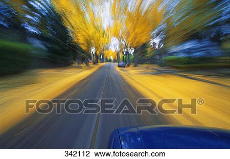 Stock Image - Speeding down a road in autumn. Fotosearch
