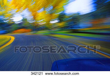 Stock Image - Speeding down a road in autumn. Fotosearch
