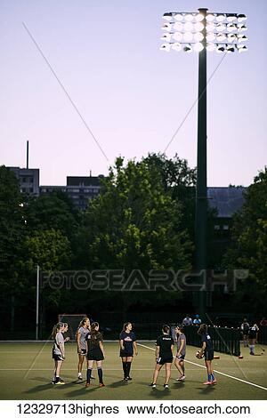 Stock Photograph - Sports Team Practice On A Field On The University Of Toronto Campus At Dusk; Toronto, Ontario, Canada. Fotosearch