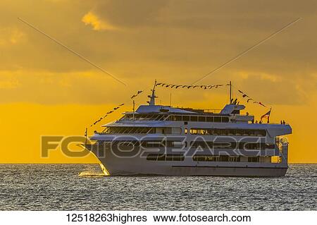 Stock Photograph - Star of Honolulu making a sunset cruise viewed from Magic Island, Ala Monana beach park; Honolulu, Oahu, Hawaii, United States of America. Fotosearch