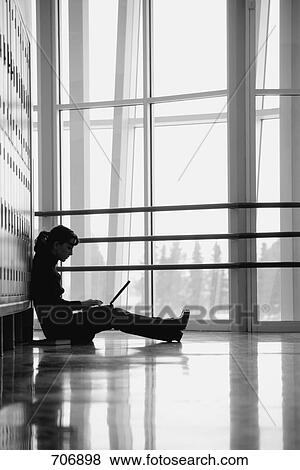 Stock Photo - Student sitting by lockers. Fotosearch